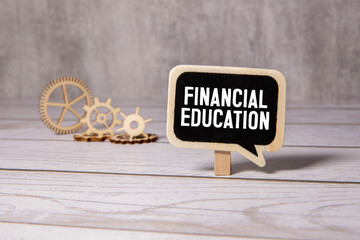 Text Financial Education on financial tables with pen, puper clips and magnifying glass. Business and financial conzept