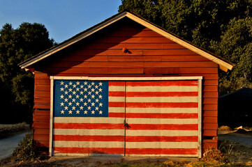 Patriotism on display. Painted American Flag on garage door illuminated by late afternoon sun 