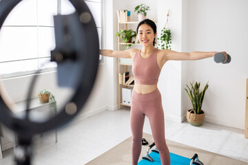 Young asian fitness woman streaming fitness training class using mobile phone. Fitness and content creator people concept.