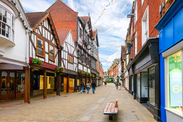 Fototapeta na wymiar Picturesque half timber frame buildings full of shops and cafes on the popular and touristic High Street in the medieval old town of Winchester, England, UK.