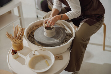 Close up of artisan's hands shaping clay bowl in pottery studio. Pottery art and creativity