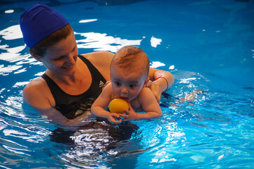 A mother and her baby boy in a swimming pool