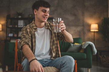 man young caucasian male teenager hold glass of water at home