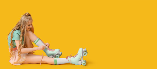 Beautiful young woman tying vintage roller skates on yellow background with space for text