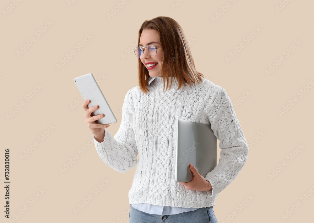 Poster female programmer with tablet computer and laptop on beige background