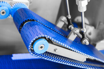 Gear chain drive shaft in conveyor belt is on production line. Timing chain of car, tensioners in engine. Industrial roller chain, technology. Team work, business industrial concept