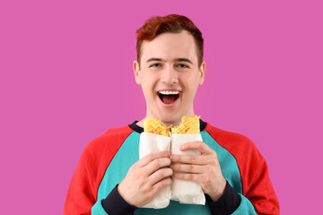 Young man with tasty sandwich wraps on purple background, closeup