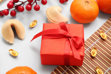 Gift box with mandarins, fortune cookies and Chinese symbols on white background. New Year...