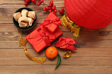Gift boxes with fortune cookies, mandarin and lantern on wooden background. New Year celebration
