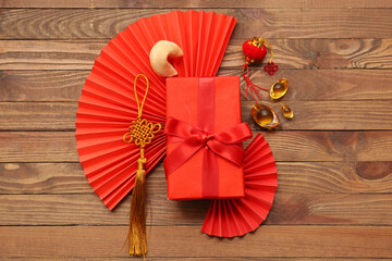 Gift box with fortune cookie and Chinese symbols on wooden background. New Year celebration