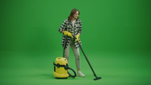 Green Screen. A Smiling Young Woman in Yellow Protective Rubber Gloves Sits on a Sofa and Satisfied with the Result of Her Cleaning. Organizing and Storing Cleaning Appliances.
