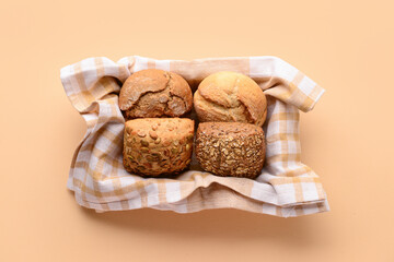 Box with different delicious buns on beige background