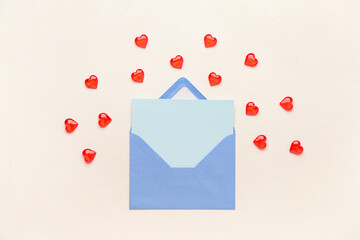 Envelope with blank card and hearts on light background. Valentine's Day celebration