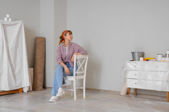 Young woman sitting during repair in room
