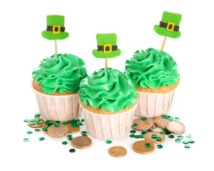 Tasty green cupcakes with golden coins and sequins for St. Patrick's Day on white background