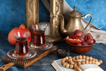 Turkish tea, fruits, Koran and prayer beads and on blue table. Ramadan celebration