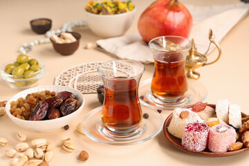 Traditional Eastern dishes, Turkish tea and decorative crescent on beige background. Ramadan...
