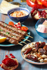 Different traditional Eastern dishes on blue wooden table, closeup. Ramadan celebration
