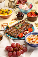 Traditional Eastern dishes and prayer beads on beige background. Ramadan celebration