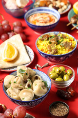 Traditional Eastern dishes on red background, closeup. Ramadan celebration
