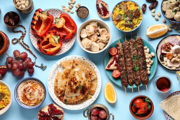 Traditional Eastern dishes and prayer beads on blue background. Ramadan celebration