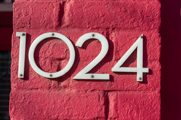 the number 1024 on a painted brick surface - obrazy, fototapety, plakaty