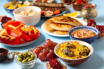 Traditional Eastern dishes on blue background, closeup. Ramadan celebration