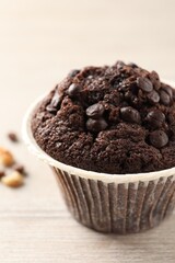 Delicious chocolate muffin on white wooden table, closeup