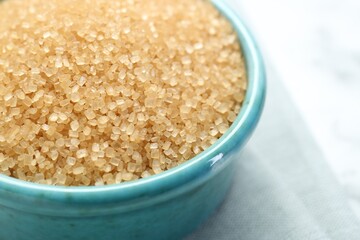Brown sugar in bowl on table, closeup