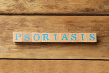 Word Psoriasis made of cubes with letters on wooden table, top view