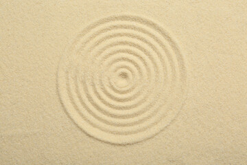 Fototapeta na wymiar Zen rock garden. Circle pattern on beige sand, top view
