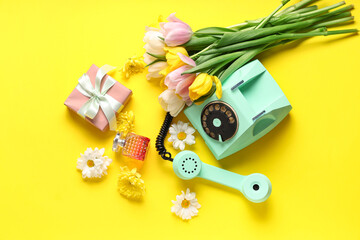 Obraz na płótnie Canvas Retro telephone with gift box, perfume and beautiful flowers on yellow background. International Women's Day