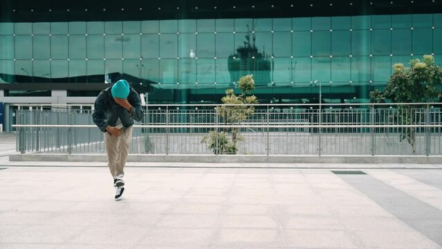 Happy hipster listen to hip hop music from headphone while dancing in lively mood. Professional street dancer perform b boy dancing at outdoor. Outdoor sport 2024. Modern lifestyle. Sprightly.