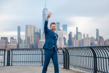 Business Man hold dollar banknote over New York City. Dollar notes concept. Credit and loan in USA. American finance. Businessman hold hundred dollar banknotes outdoor. Celebrating the success.