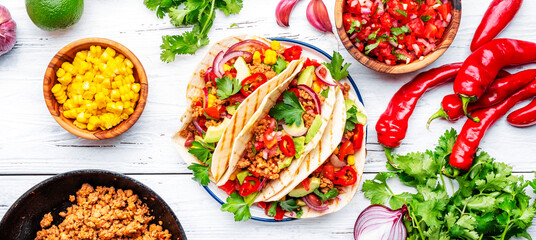 Tacos with ground beef, sweet corn, red beans, tomato salsa sauce and red onion in corn tortillas on plate. Mexican cuisine. Taco party menu. White table background, top view banner