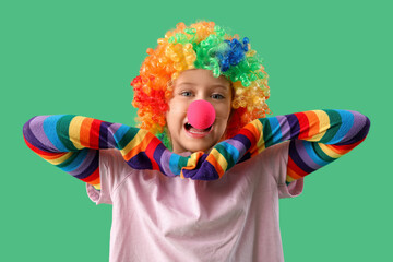 Funny girl in clown costume on green background. April Fool's Day celebration