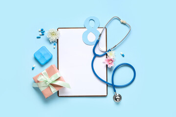 Composition with blank clipboard, stethoscope, pills and gift for International Women's Day on color background