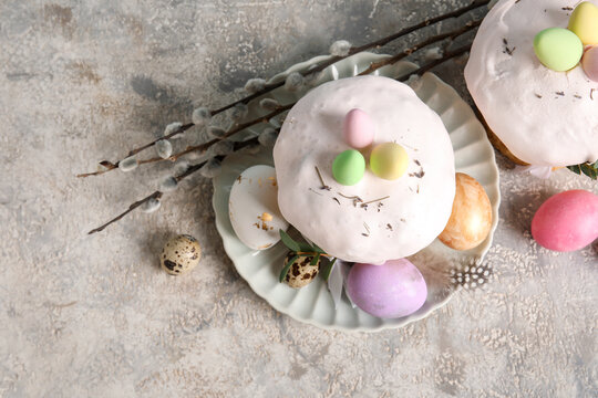 Composition with delicious Easter cakes and painted eggs in plate on color background. Top, view
