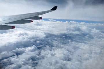 Fototapeta na wymiar 飛行機の窓から見る雲の上の空