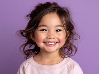 little Asian girl with colorful sweatshirt in professional colorful photo studio background