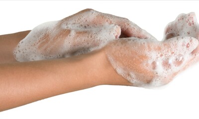 cropped view of female hands in soap foam isolated on beige