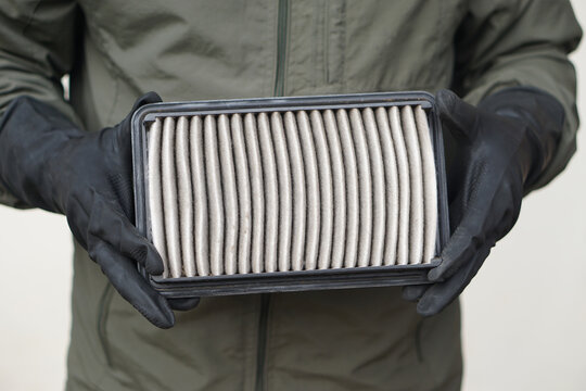 Closeup mechanic's hands hold air filter pad of car engine to check. Concept, car broken,repair and maintenace service. Dirty air fillter need to change for hygienic.   