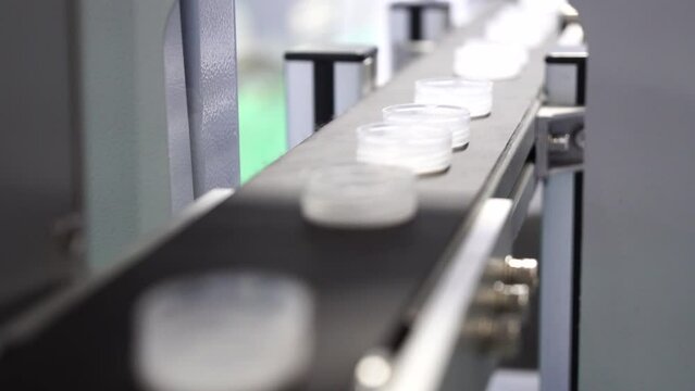The plastic drinking water caps on the conveyor belt.