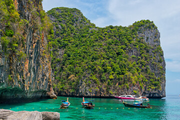 KOH PHI PHI, THAILAND - MARCH 11 2022: Motor boats on turquoise water of Maya Bay lagoon on MARCH 11, 2022 in Koh Phi Phi island, Thailand. This was extremely quiet due to the Covid 19 pandemic.