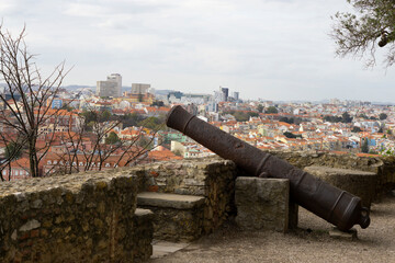 Old cannons in the Lisbon bastion. Castelo de S. Jorge cannons and view on the city. Ancient weapons.