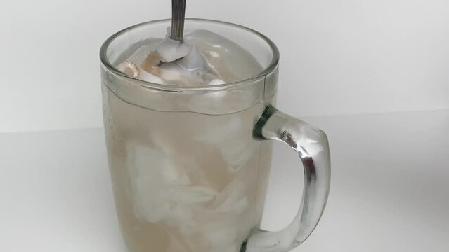 Beverage made from chilled or iced coconut water and young coconut flesh, isolated on white background