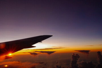 Fototapeta premium 飛行機の窓から見た夕暮れの空の写真
