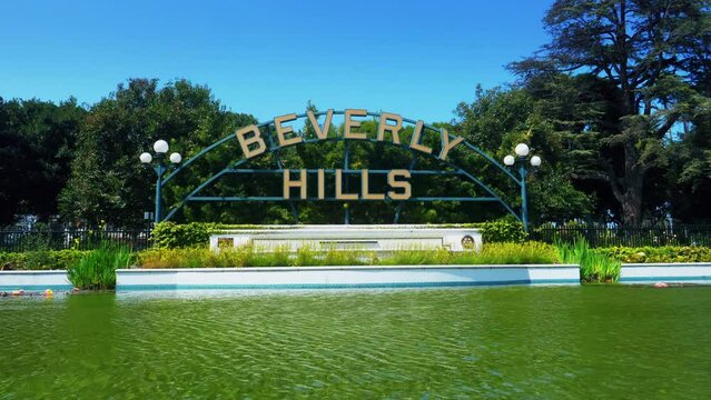 Beverly Hills, California, United States &ndash; April 16, 2019: Beverly Hills main city sign. Beverly Hills landmark and lake with sunlight reflection. City name at Beverly Gardens Park.
