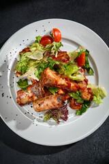 Top view of BBQ ribs with a salad mix on a white plate