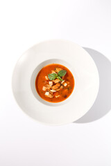 Classic Italian tomato seafood soup viewed from above, isolated on white, perfect for elegant menu design and food blogs